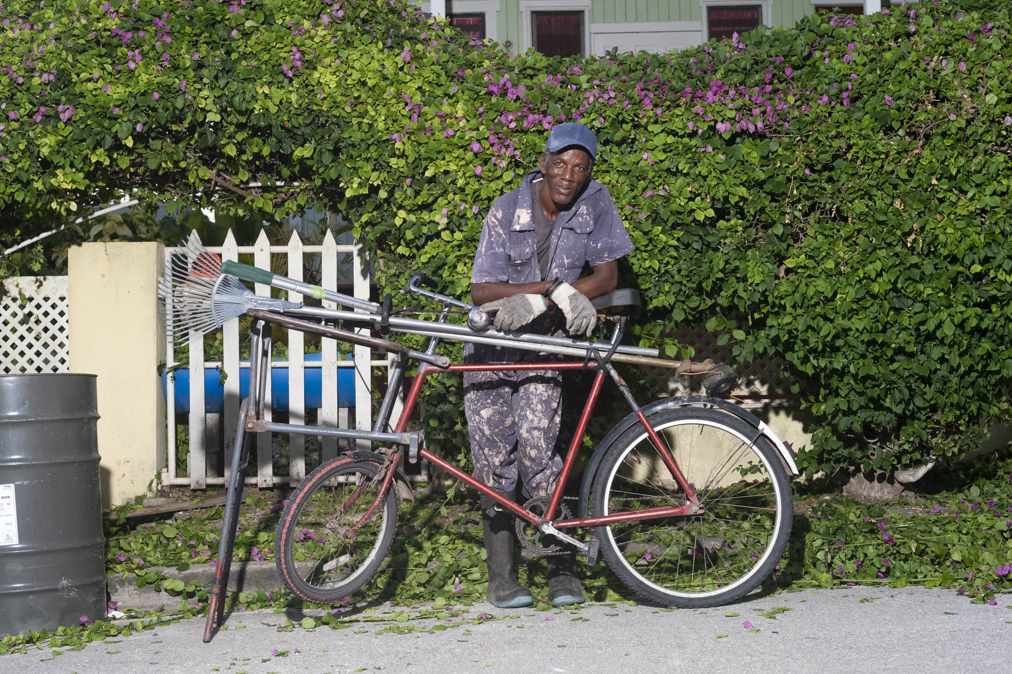 Omar Pander with a bicycle and landscaping equipment in Barbados