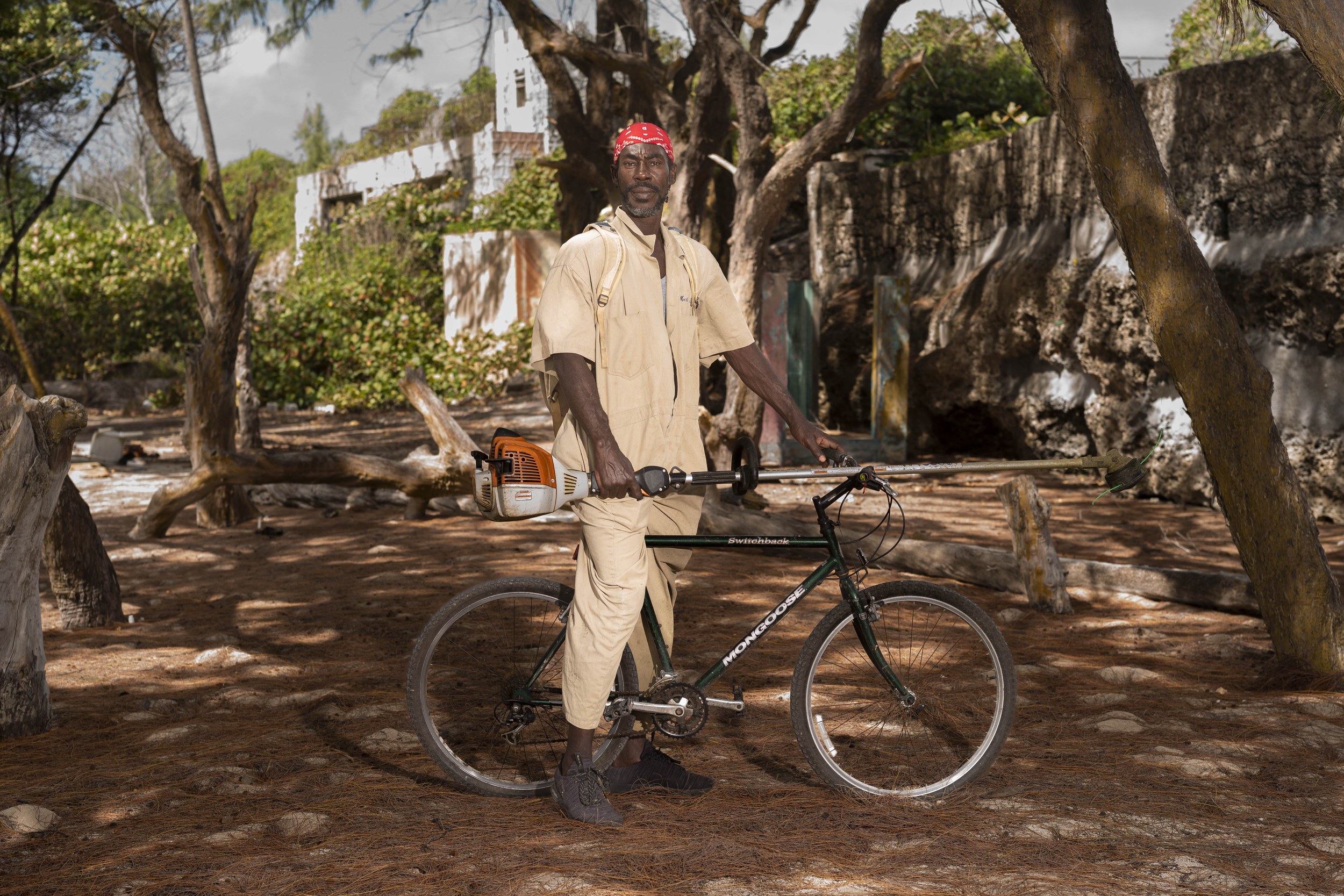 Alvin Boden with a bicycle and landscaping equipment in Barbados