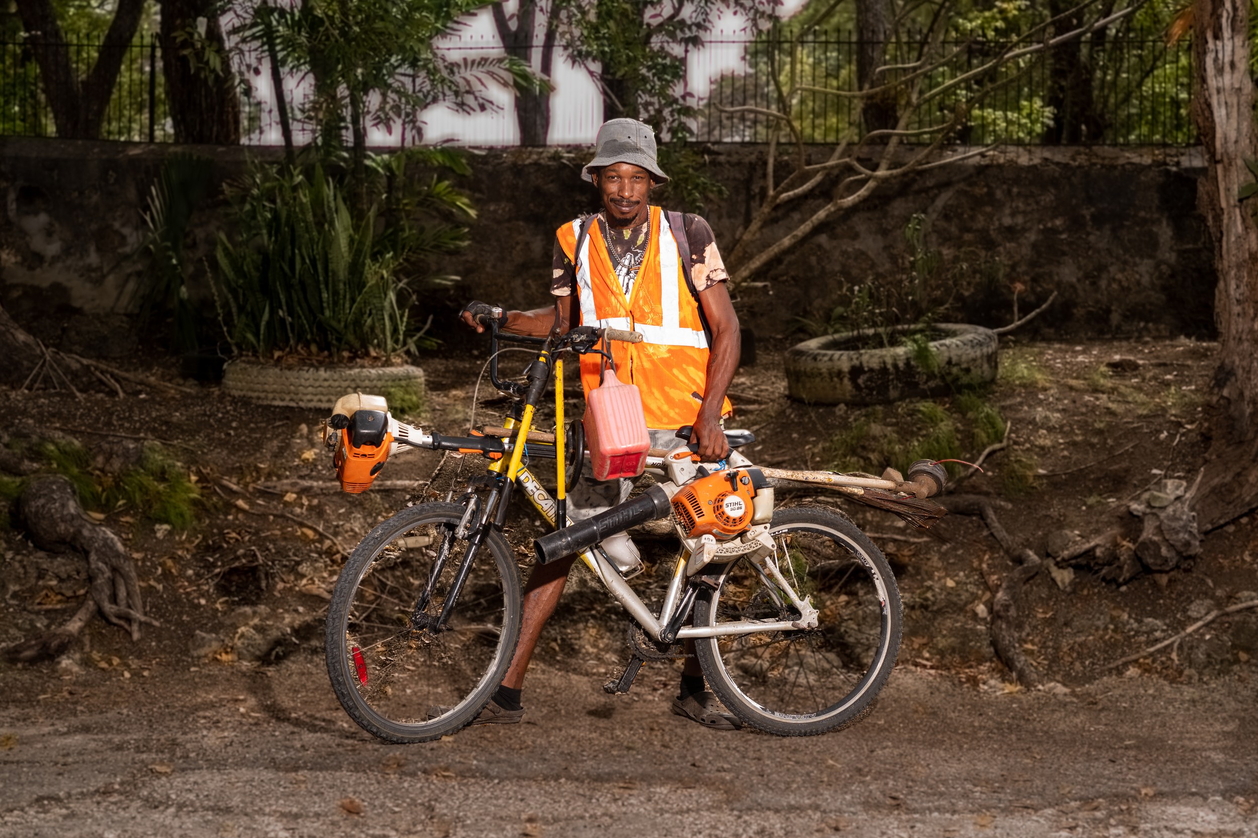 Kent Bovell with a bicycle and landscaping equipment in Barbados