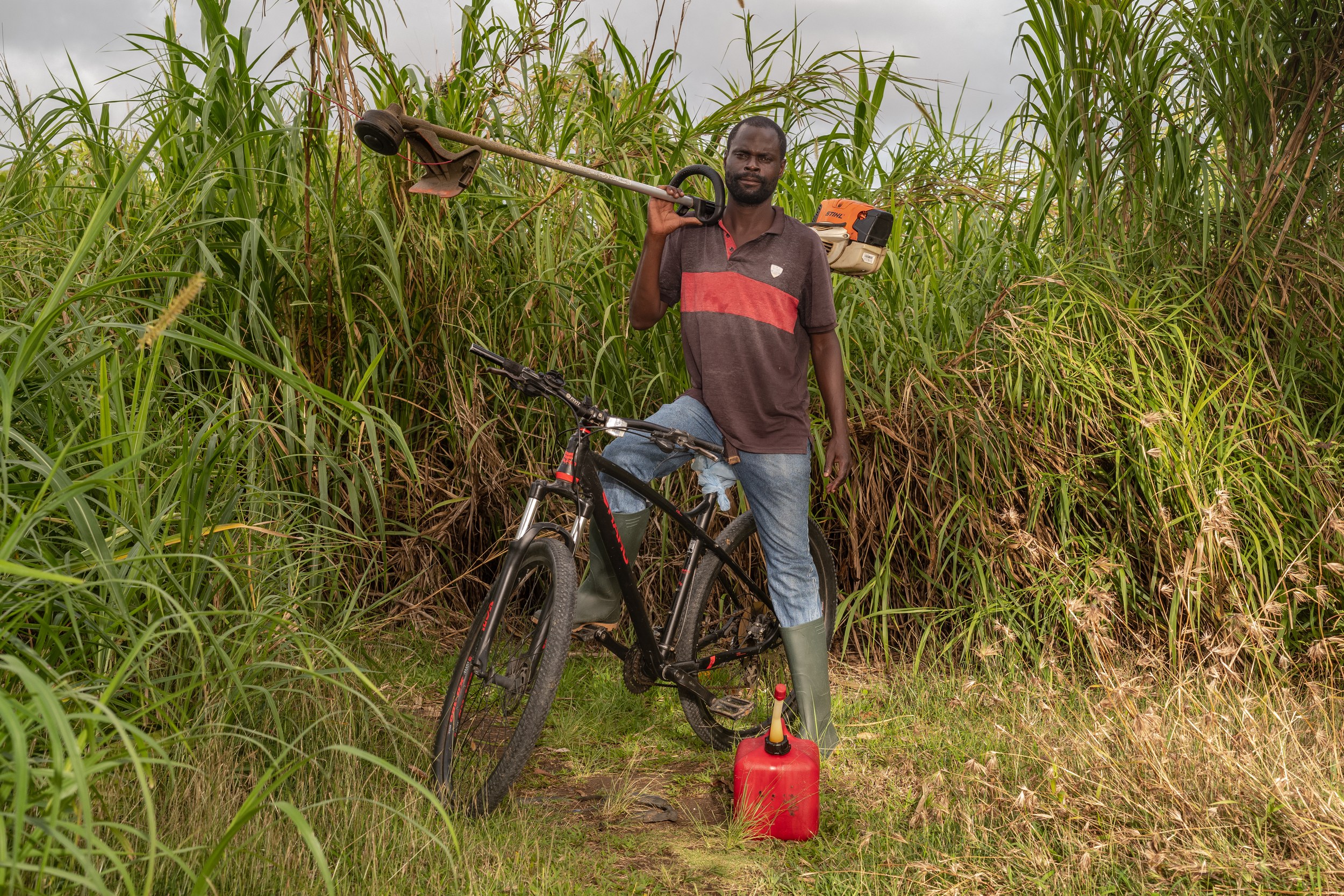 Anderson Baker with a bicycle and landscaping equipment in Barbados