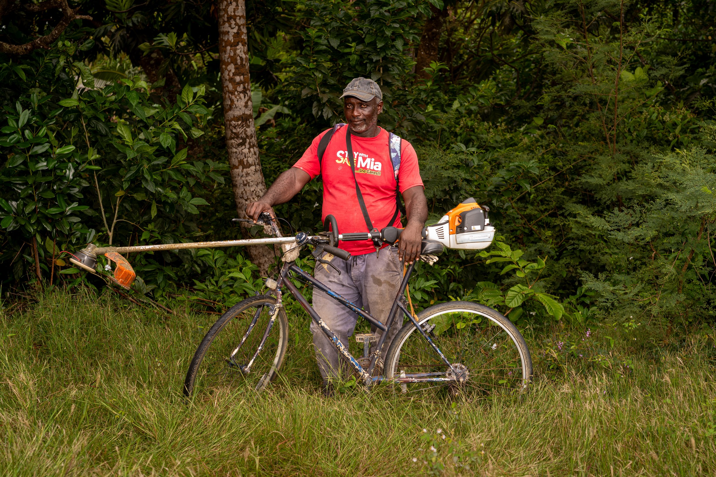 Junior “Woody” Franklin with a bicycle and landscaping equipment in Barbados