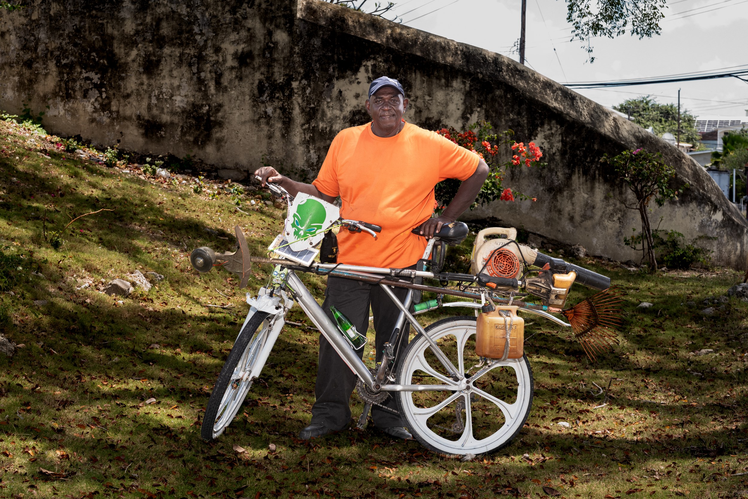 Karl Herbert with a bicycle and landscaping equipment in Barbados