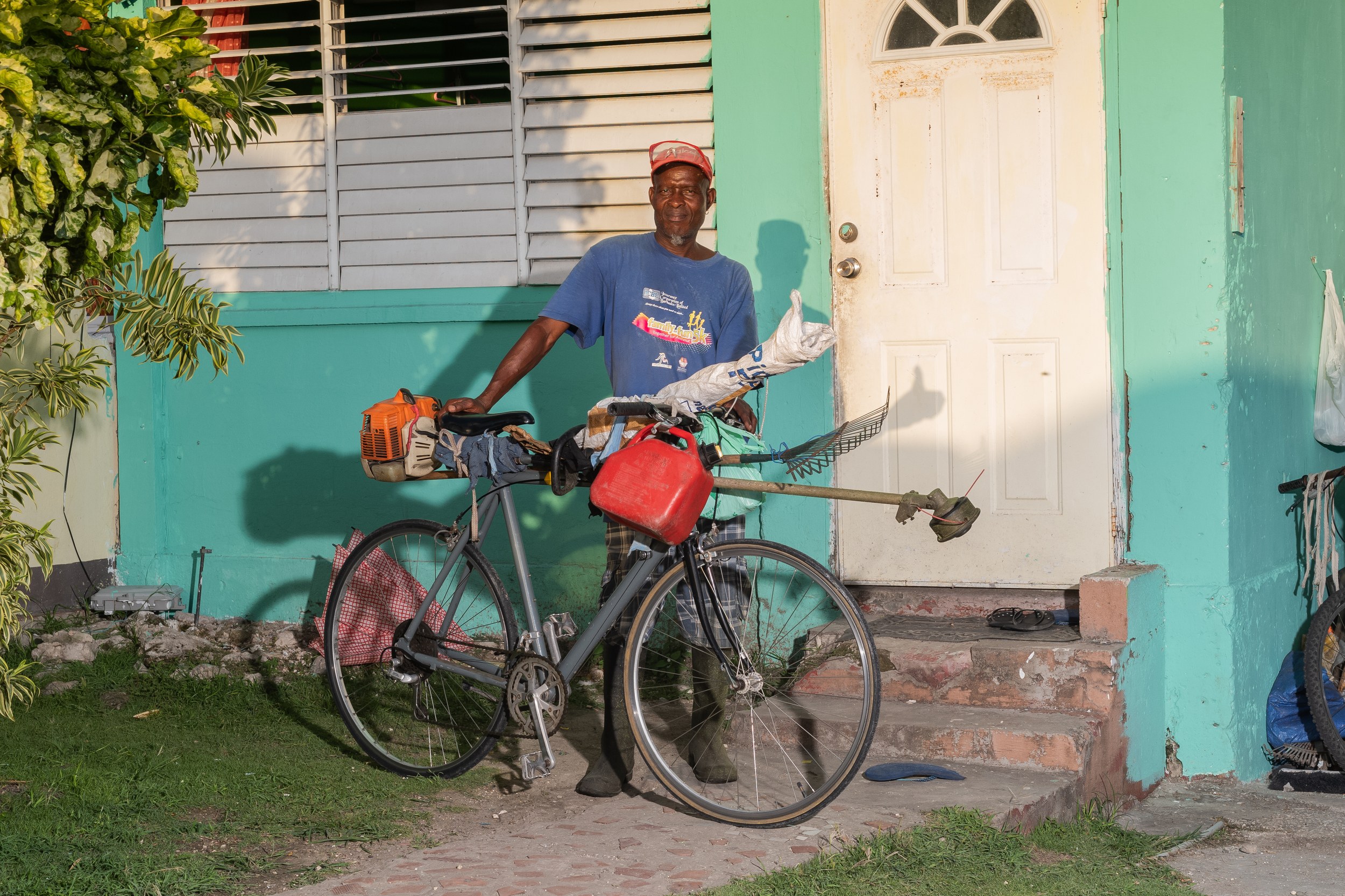 David Goodrich with a bicycle and landscaping equipment in Barbados