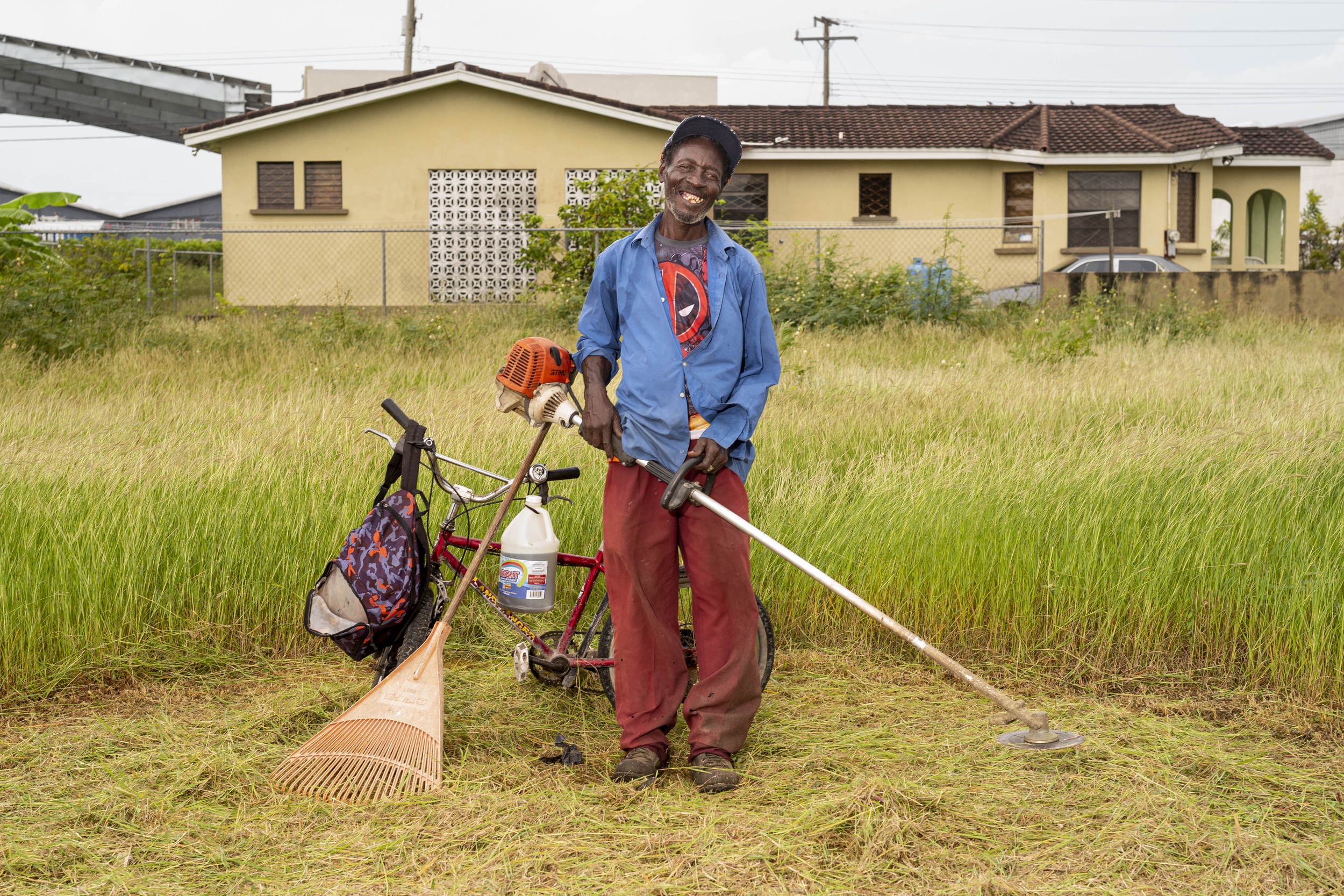 Colvin Green with a bicycle and landscaping equipment in Barbados