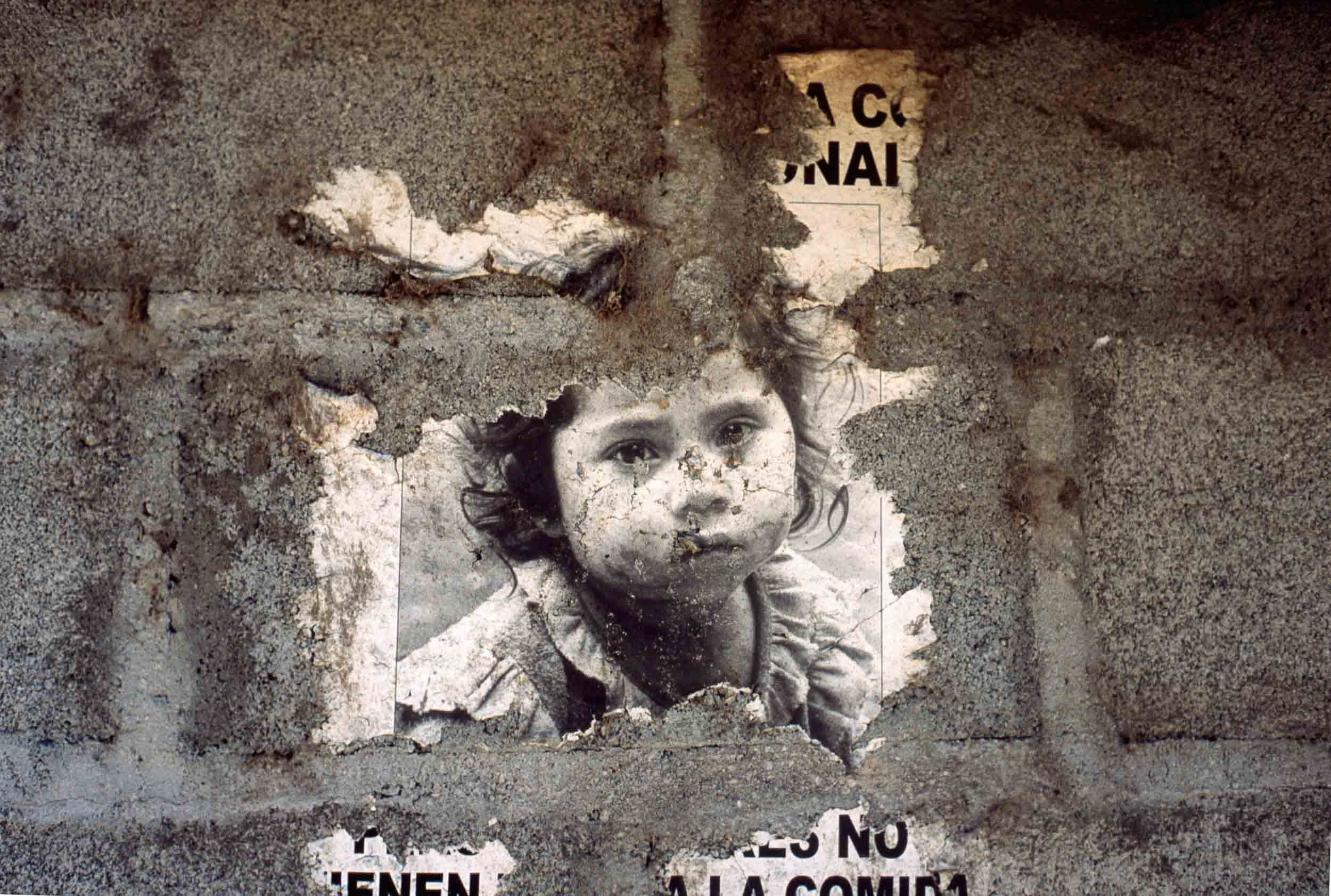 A weathered sign requesting aid for hungry children, El Salvador, 2005