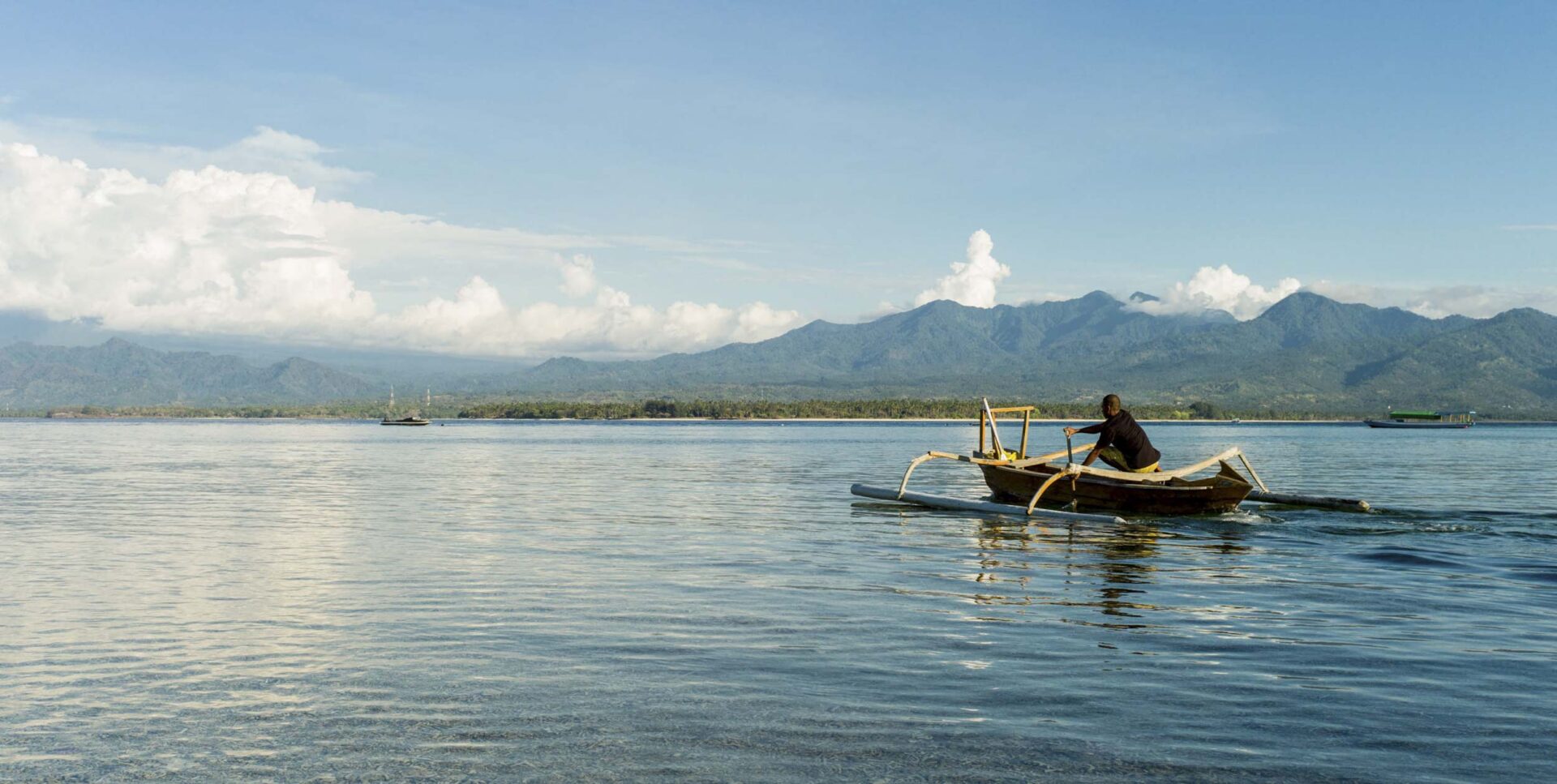 A traditional paddleboat photographed from Indonesia’s tiny island of Gili Air, with Lombok (and its active volcano) in the distance, 2011