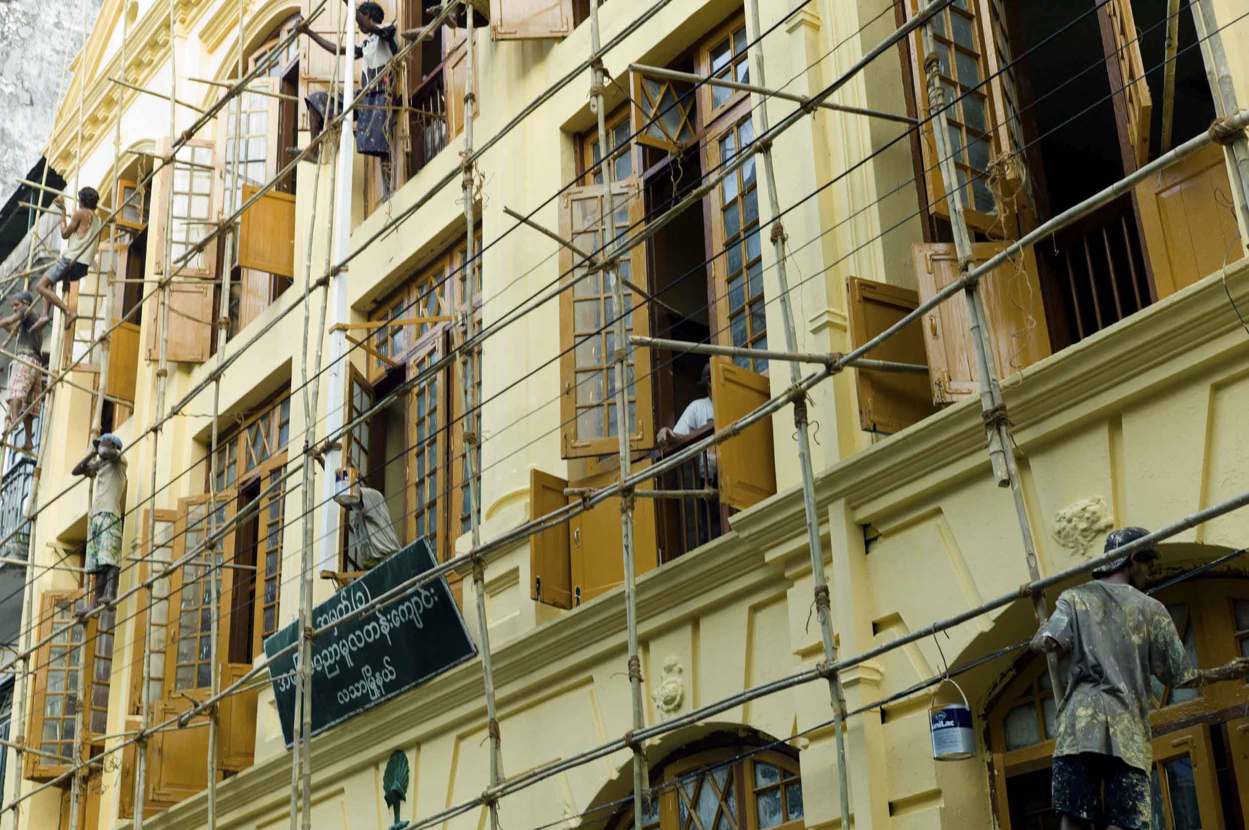 Painters use bamboo scaffolding to repaint a building in central Yangon, 2012