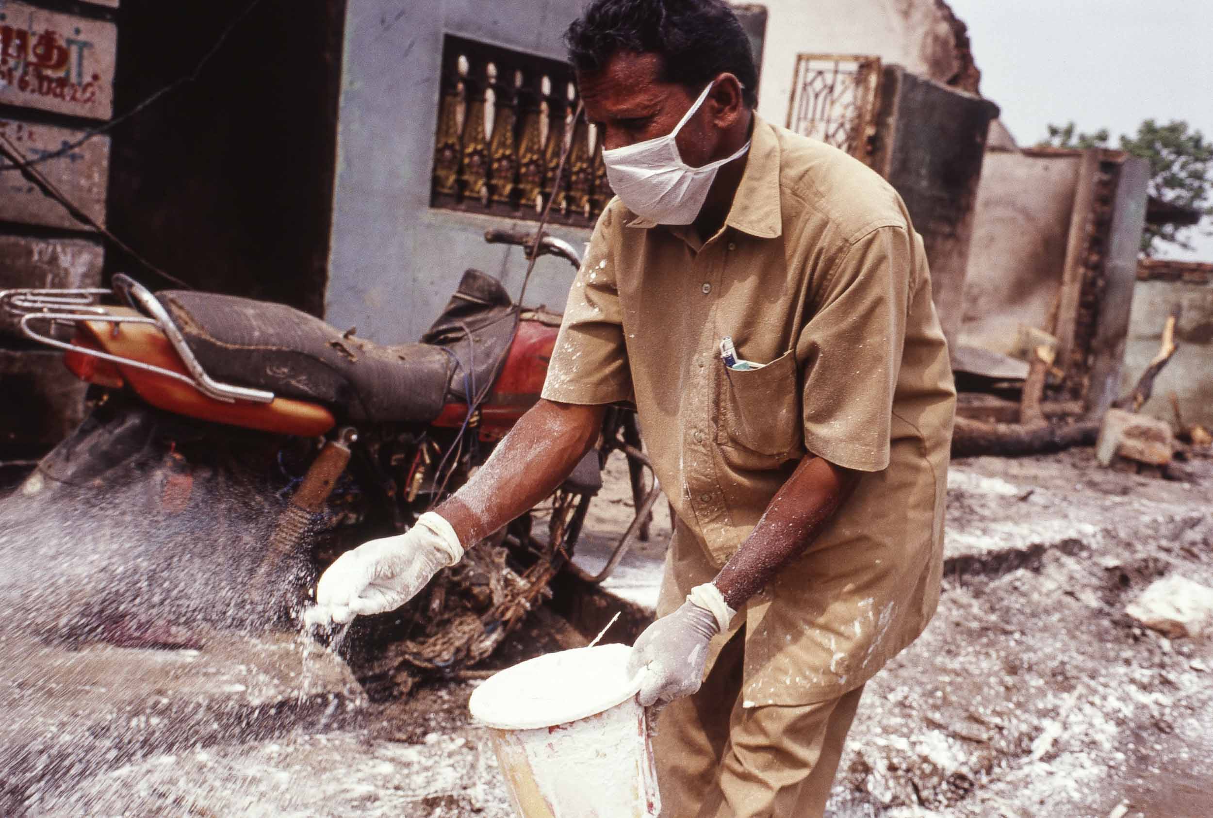 A relief worker bleaching streets to stave off outbreaks of disease. Nagapattinam, India, 2005